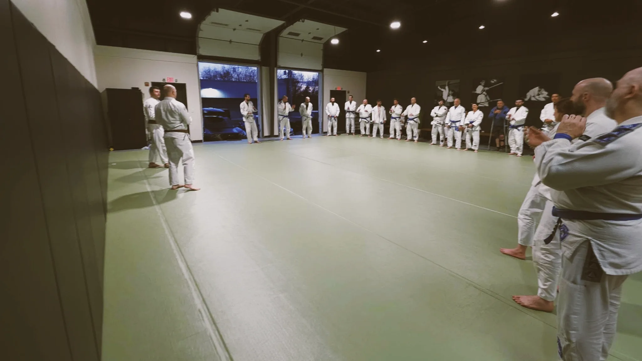 A large class gathered in a circle on opening day in the academy's main training room.