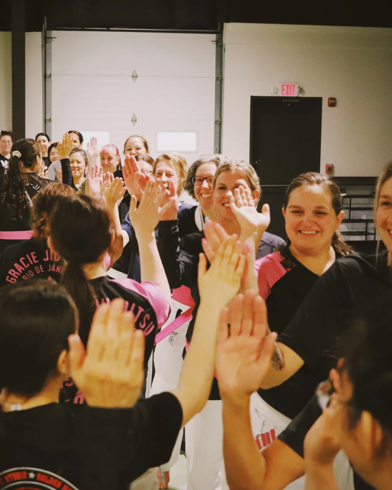 Women Empowered students high-fiving in a line at the end of class.