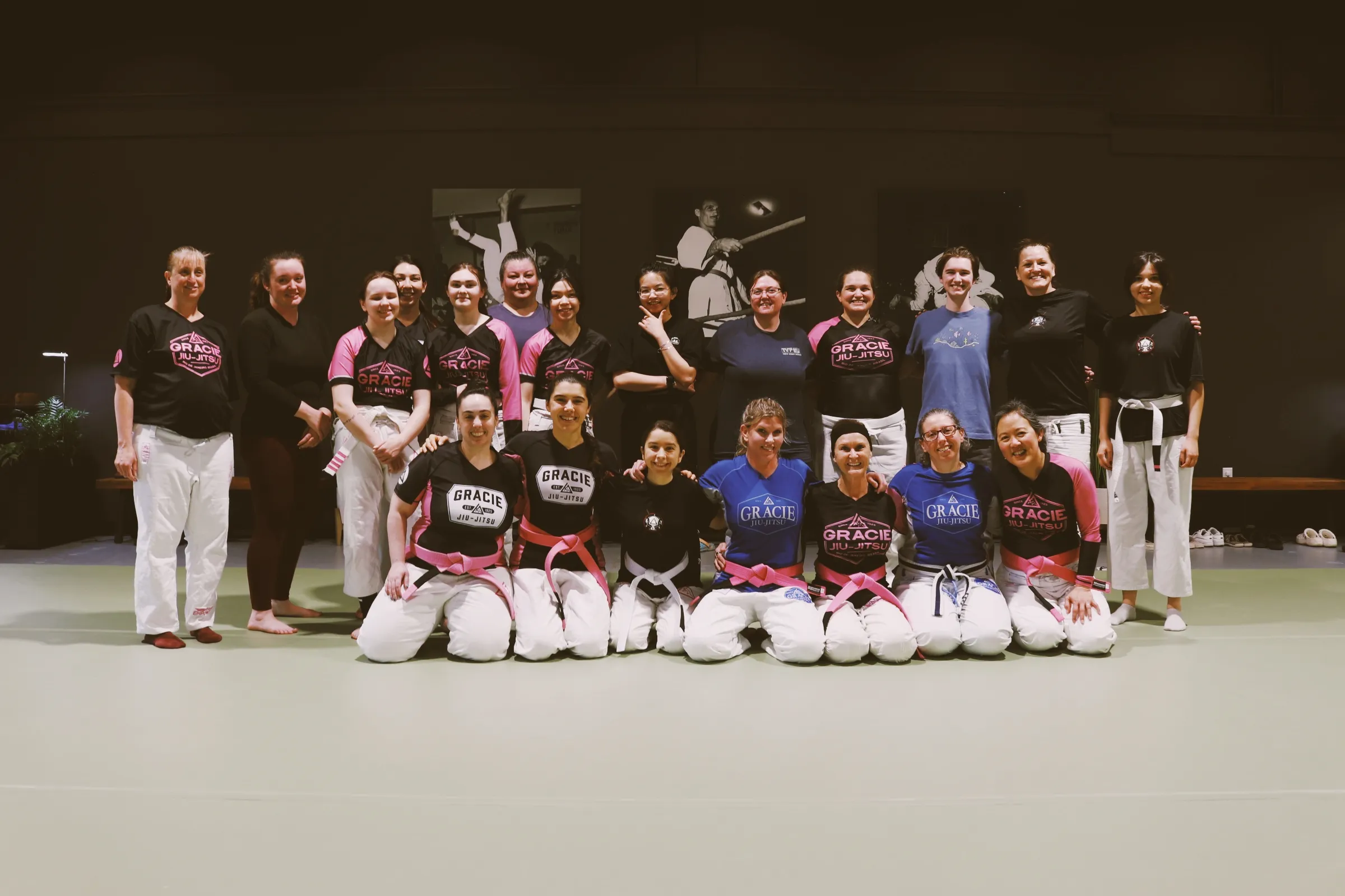 A group of women from the Women Empowered program posing together on the mat.